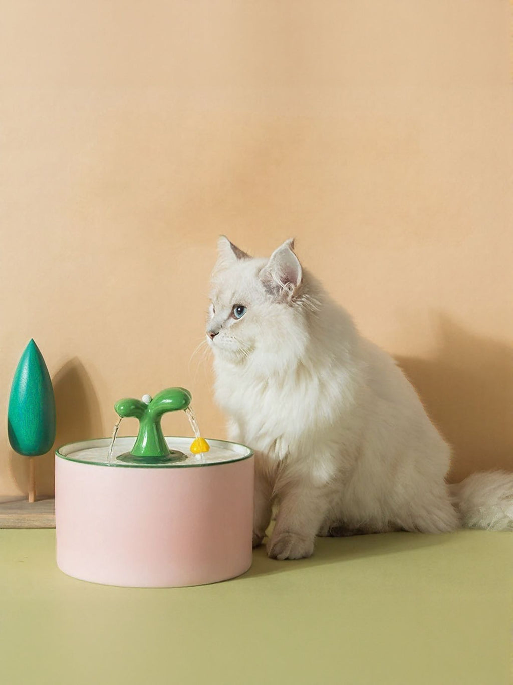 Automatic pet fountain in watermelon pink with green spout, cat drinking