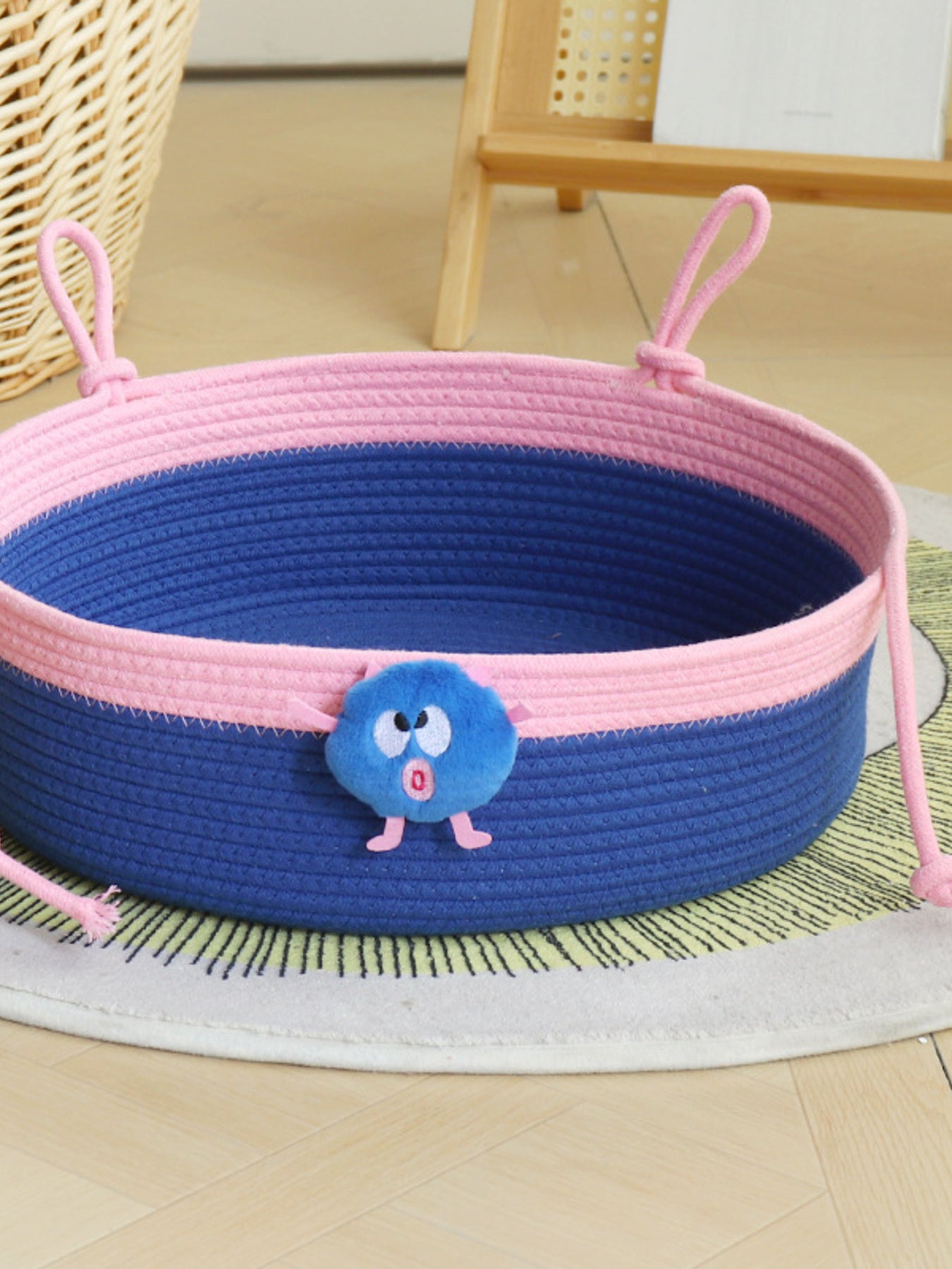 Two-tone woven pet nest: blue woven sides with pink rim and hanging loop handles