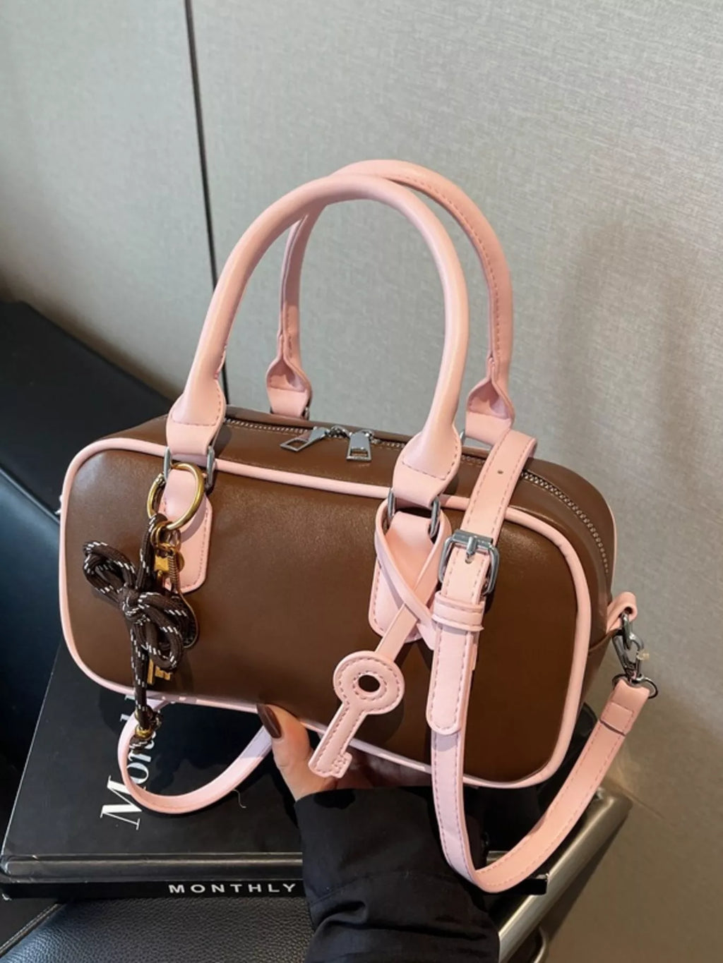Barrel Crossbody Bag mit Schlüsselanhänger, braunem Korpus und rosafarbenen Riemen