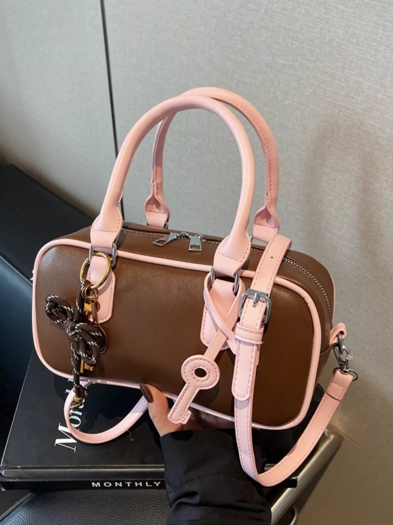 Barrel Crossbody Bag mit Schlüsselanhänger, braunem Korpus und rosafarbenen Riemen