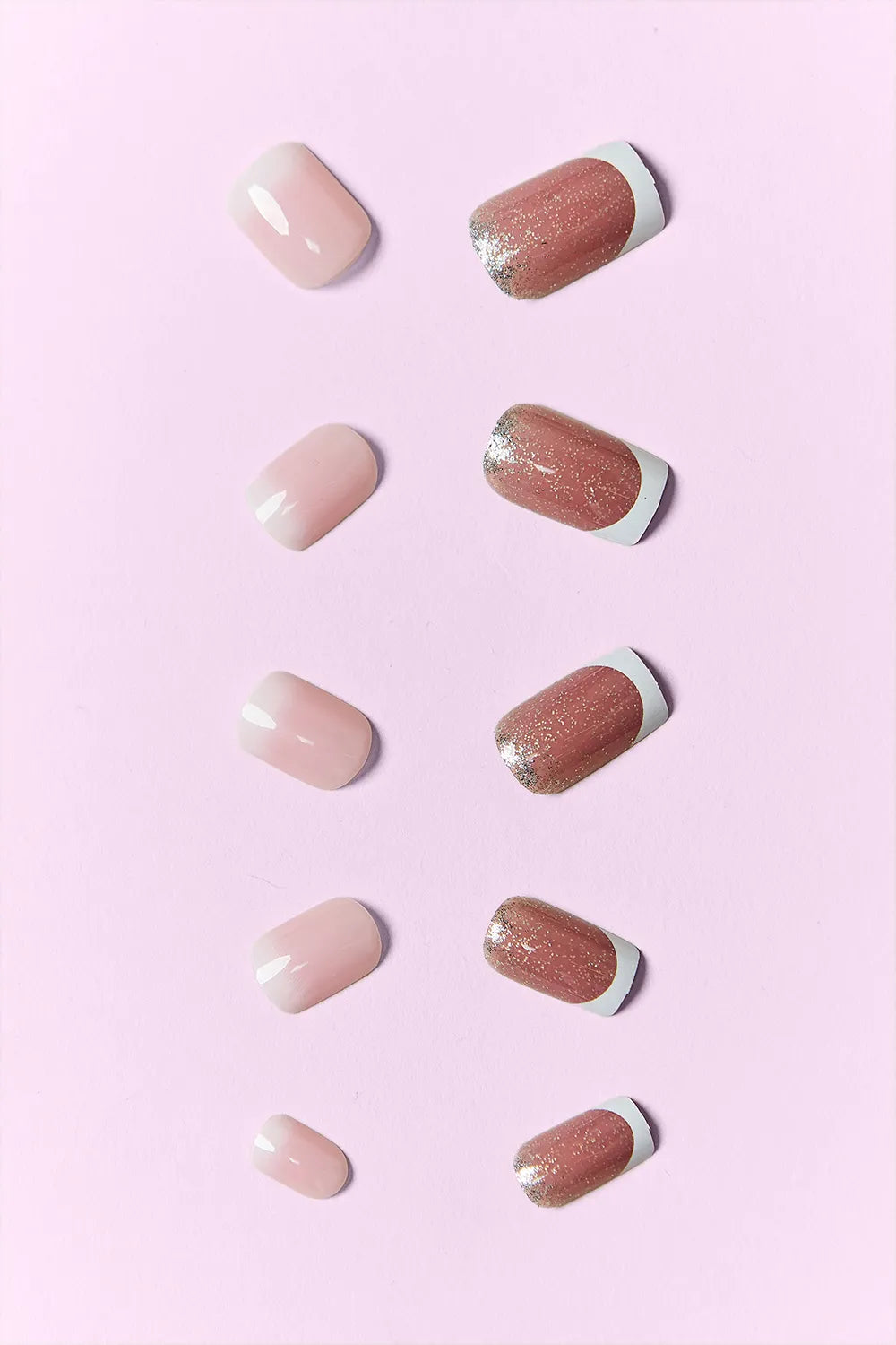 Press-on nail tips in nude and blush with rose glitter accents