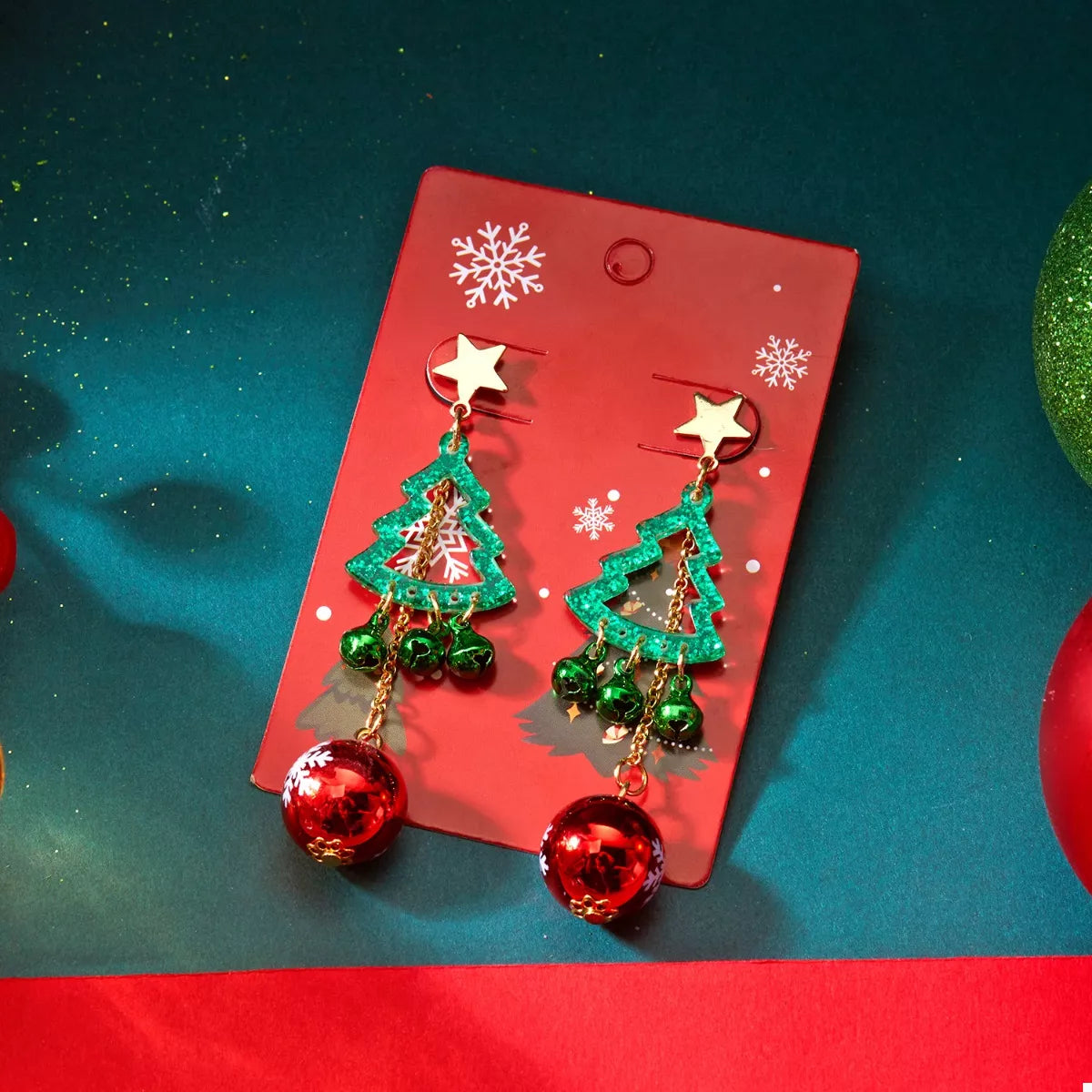 Pair of Christmas tree ball drop earrings on card: green trees and red snowflake baubles