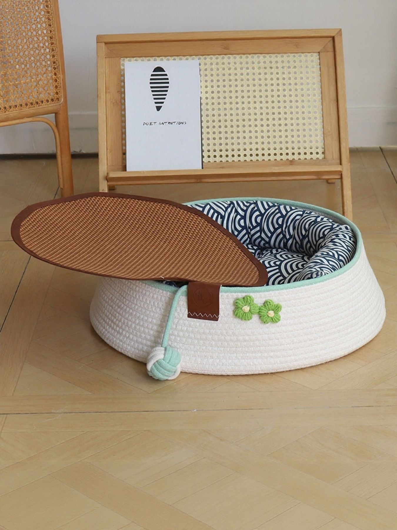 Woven pet nest in white with mint trim; brown oval lid with patterned cushion inside
