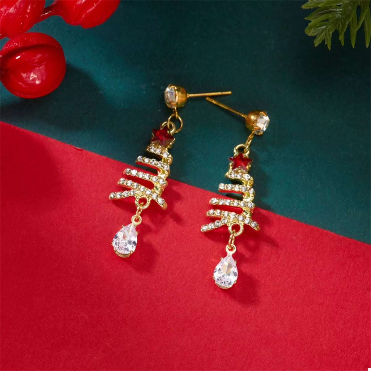 Gold-tone Christmas tree earrings with red star, rhinestone tree details, clear teardrop dangles