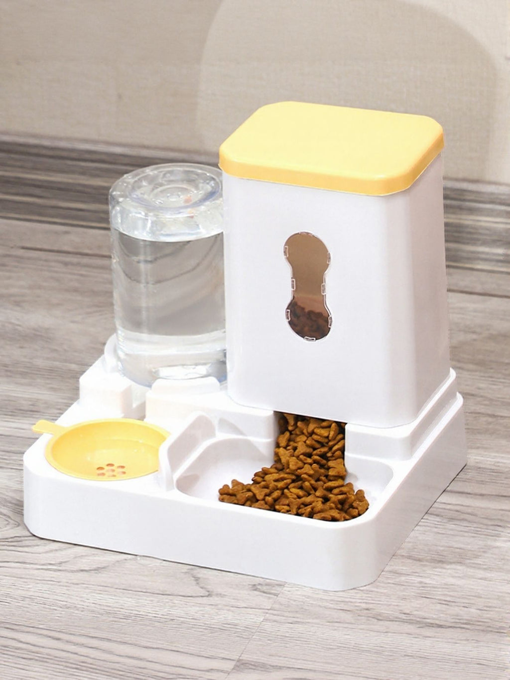Automatic pet food and water dispenser with yellow lid, food tray and water tank.
